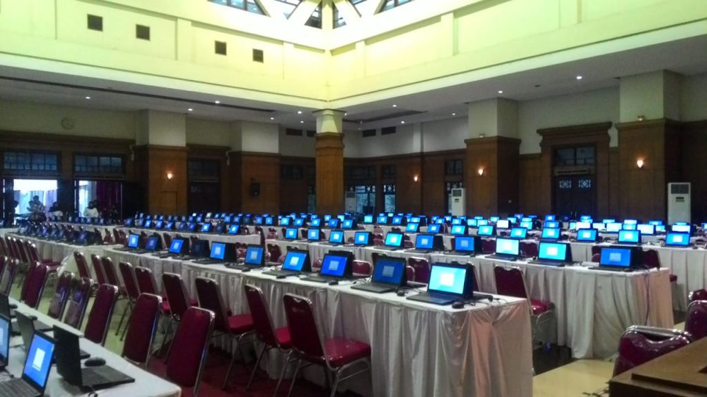 Deretan laptop di atas meja dalam sebuah ruang kegiatan